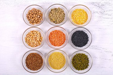 Beyaz ahşap zemin üzerinde çeşitli sağlıklı organik tahıl. 