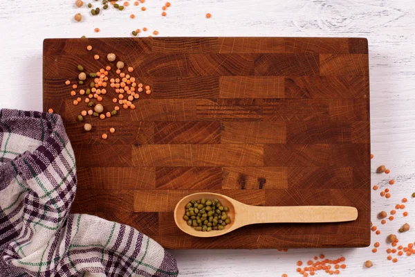 Rustieke houten plank, geruite servet en linzen zaden met cop — Stockfoto