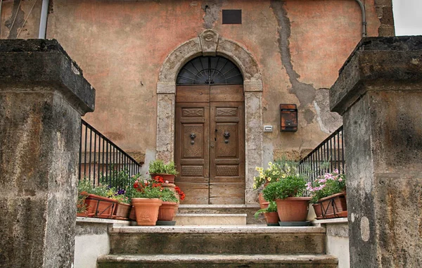 Vieille porte en bois décorée avec des pots de fleurs de la ville médiévale — Photo