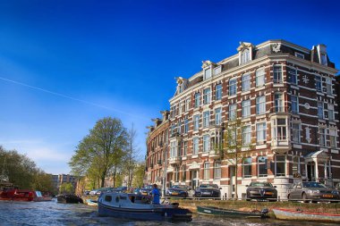 Cityscape tarihi binaları ve teknelerle Amsterdam kanal ile