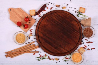 Kahverengi yuvarlak kesme tahtası üzerinde beyaz ahşap masa etrafında gıda çerçeve