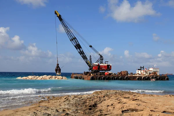 Crane on barge stacks stones in sea to protect shore from waves, Pathos, Cyprus — Stock Photo, Image