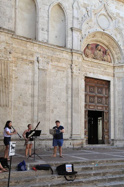 Músicos de rua em degraus da Catedral na cidade toscana Montepulciano, Itália — Fotografia de Stock