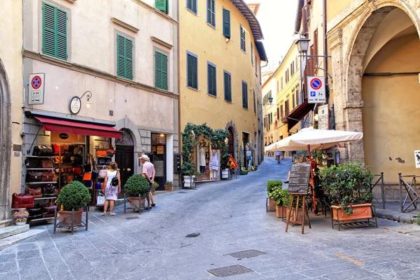 Turistas, tiendas de recuerdos y cafeterías en Montepulciano medieval, Toscana —  Fotos de Stock