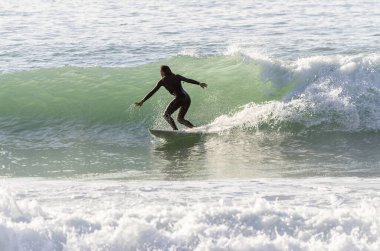 Dalgalarda sörf yapan sörfçü.