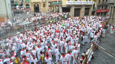 Kalabalık geleneksel beyaz gömlek ve kırmızı boyun bağları Pamplona sokaklarında San Fermin Festivali sırasında satır. Bask Ülkesi İspanya. -10 Temmuz 2013
