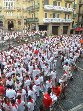 Kalabalık geleneksel beyaz gömlek ve kırmızı boyun bağları Pamplona sokaklarında San Fermin Festivali sırasında satır. Bask Ülkesi İspanya. -10 Temmuz 2013