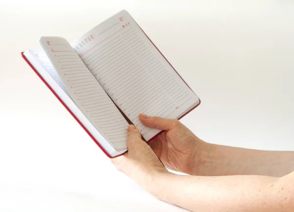 Γυναικεία Χέρια Γράφουν Ένα Κόκκινο Μολύβι Ένα Σημειωματάριο Λευκό Φόντο — Φωτογραφία Αρχείου
