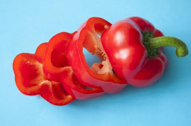 Mavi arkaplanda dilimlenmiş kırmızı biber