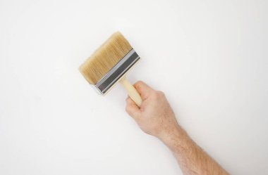 İnşaatçılar el ve fırçayla yapıştırır. Duvarı onarım ve onarım için hazırlıyorum..