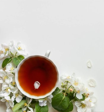 Bahar kahvaltısı. Masada bir fincan çay ve elma ağacının çiçekleri..