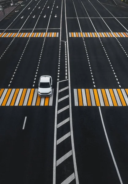 空の道路上の1台の車 隔離された都市 道路標示と横断歩道 — ストック写真