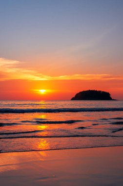 Tayland 'da Parasailing uçuşu. Güneş denizde gün batımında batar. Sahilde dalgalar.