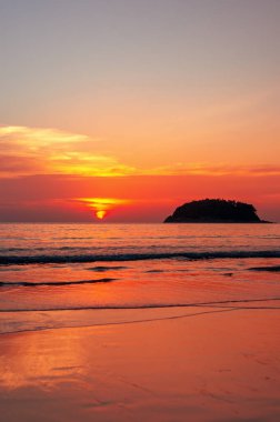 Tayland 'da Parasailing uçuşu. Güneş denizde gün batımında batar. Sahilde dalgalar.