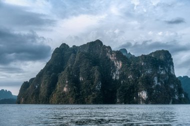 Göl kenarındaki dağlar. Tayland 'da tropik bir manzara. Cheo Lan Gölü ve Khao Sok Ulusal Parkı.