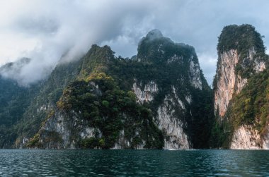 Dağlarda sis var. Tayland 'da tropik bir manzara. Cheo Lan Gölü ve Khao Sok Ulusal Parkı.