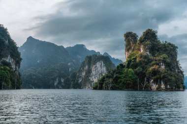 Göl kenarındaki dağlar. Tayland 'da tropik bir manzara. Cheo Lan Gölü ve Khao Sok Ulusal Parkı.