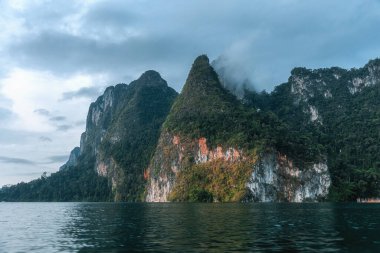 Dağlarda sis var. Tayland 'da tropik bir manzara. Cheo Lan Gölü ve Khao Sok Ulusal Parkı.
