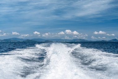 Sudaki motordan alınan iz. Gemiden hat spreyi. Deniz, ada ve gökyüzü.