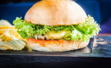 Klasik burger, kızarmış pirzola, peynir, salata, yakın çekim.