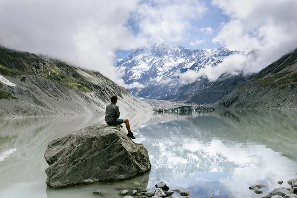 Mann Sitzt Auf Felsen Nahe Blauem Teich Berg — Stockfoto