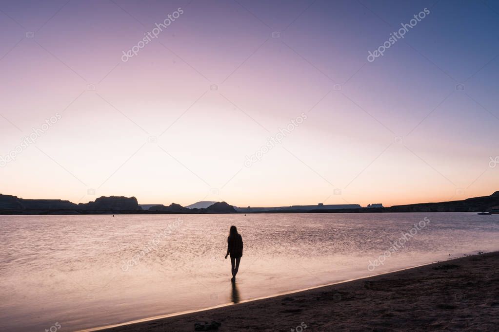 Woman walking by beach at sunset