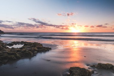 Kuzey Queensland 'da okyanusun üzerinde güzel turuncu gün doğumu, beyaz kumlu sahil