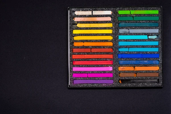 pastel crayons for drawing in a black box on a black background