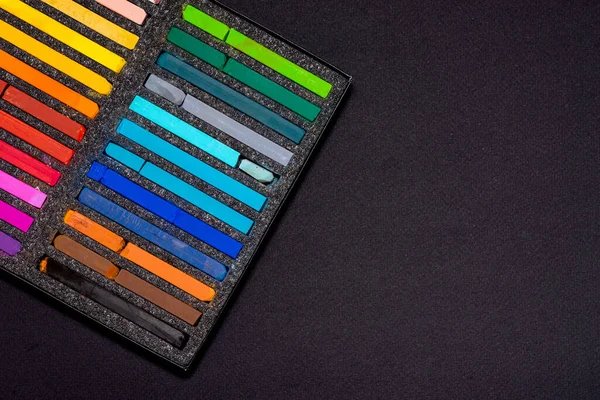 pastel chalks for drawing in a black box on a black background