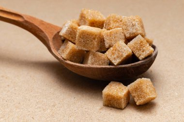 kahverengi rafine şeker ahşap kaşık üzerinde kağıt zemin üzerinde