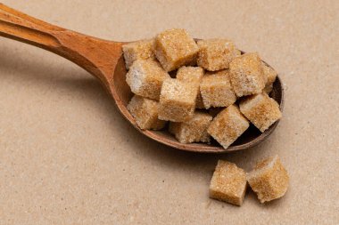 kahverengi rafine şeker ahşap kaşık üzerinde kağıt zemin üzerinde