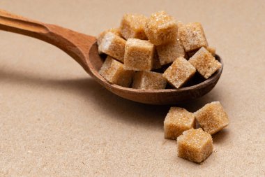 kahverengi rafine şeker ahşap kaşık üzerinde kağıt zemin üzerinde