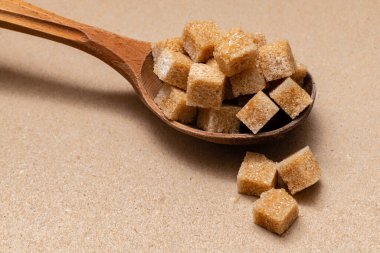 kahverengi rafine şeker ahşap kaşık üzerinde kağıt zemin üzerinde