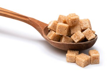 Tahta bir kaşıkta beyaz bir zeminde kahverengi rafine şeker.