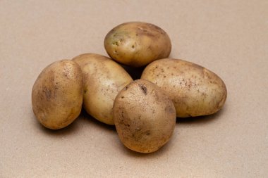 Bir zanaat rengi arka planında çiğ patates