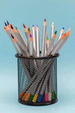 Gri tahta kalemler mavi arkaplanda renkli çubuklar var.