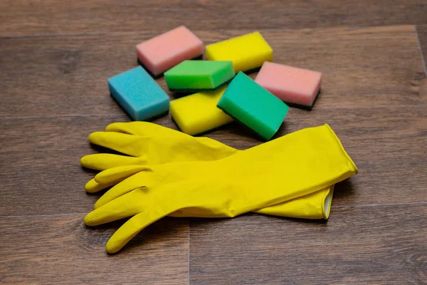 yellow rubber gloves and washcloths on wooden background