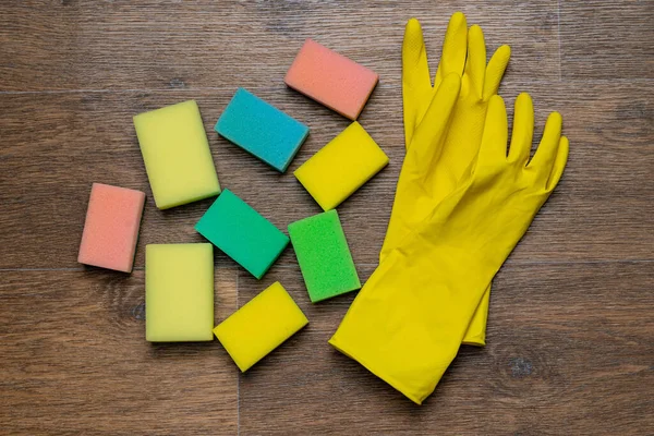 yellow rubber gloves and washcloths on wooden background
