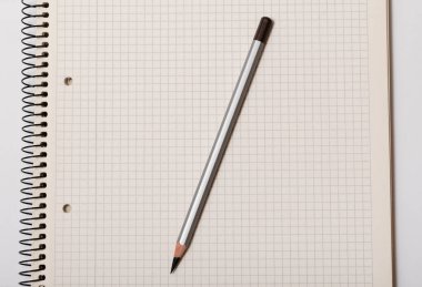 beyaz arkaplanda beyaz işaretli defter ve gri kalem