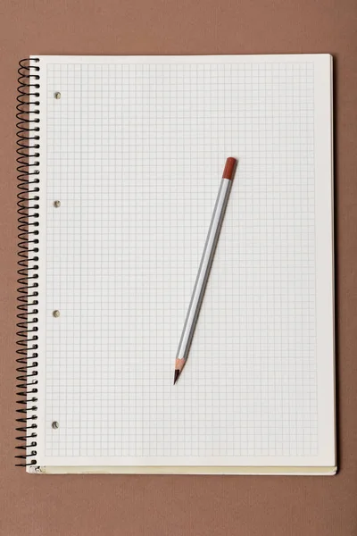 Branco Caderno Verificado Lápis Cinza Fundo Marrom — Fotografia de Stock