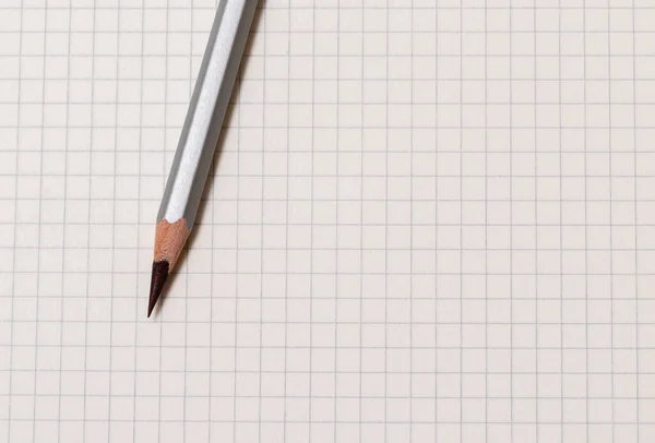 ホワイトチェックのノートと木製のグレーの鉛筆のクローズアップ — ストック写真
