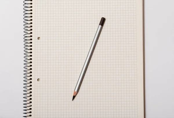 Branco Caderno Verificado Lápis Cinza Fundo Branco — Fotografia de Stock