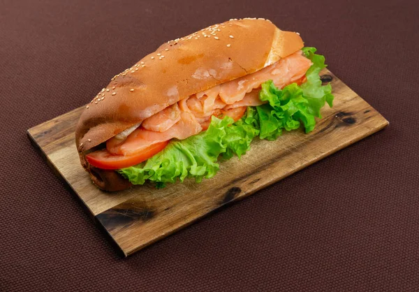 의나무 판위에 연어와 양상추를 커다란 샌드위치 — 스톡 사진