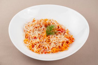 domates soslu makarna, peynir, mantar ve otlar bej kumaş arka planda beyaz bir tabakta.