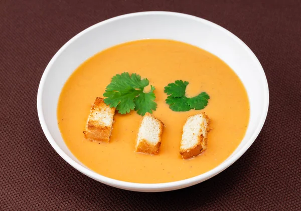 Σούπα Κολοκύθας Πορτοκαλιού Κρουτόν Και Βότανα Λευκό Πιάτο Μπεζ Φόντο — Φωτογραφία Αρχείου