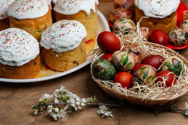 Ciasta Wielkanocne Pisanki Wiklinowym Koszu Kwitnącą Gałązką Drewnianym Tle — Zdjęcie stockowe