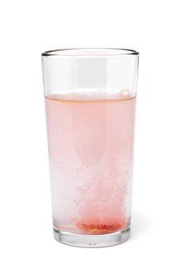 Beyaz arka planda su bulunan cam bardakta çözünür multivitamin.