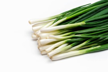 Beyaz arka planda bir sürü taze soğan.