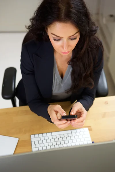 Professionell kvinna sitter med mobiltelefon — Stockfoto