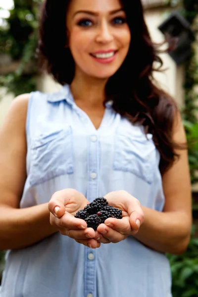 Mujer sonriente sosteniendo moras —  Fotos de Stock